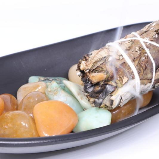 Golden healer quartz and Chrysoprase in a black dish with a sage smudging stick