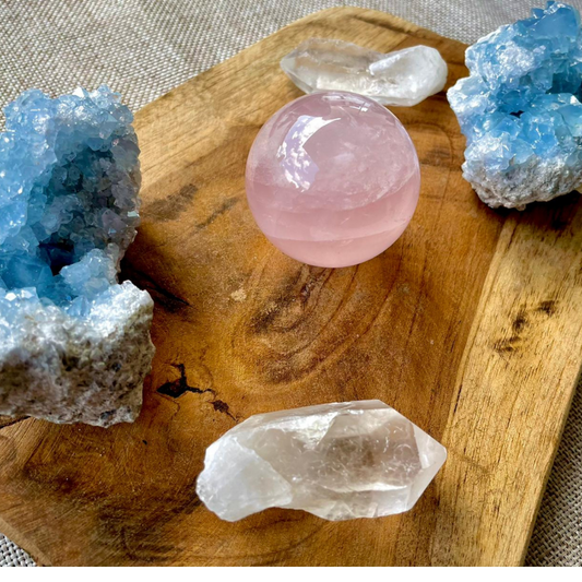 Rose quartz, celestite and clear quartz on a wooden tray